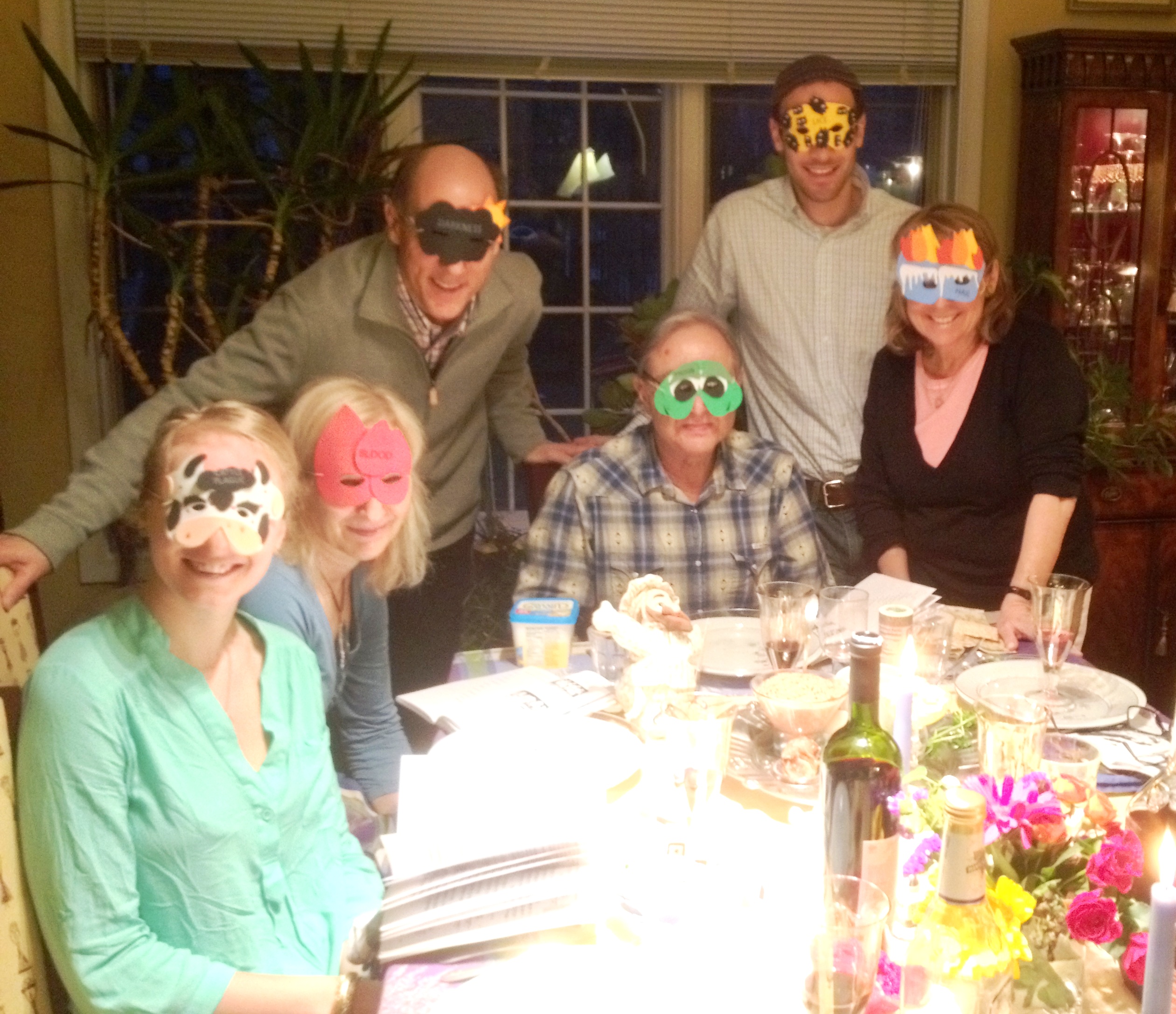 Passover seder 2 with plague masks.JPG